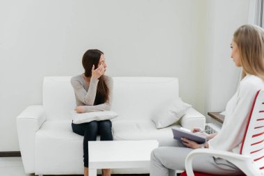 Genç bir kadın bir psikoterapistle görüşmeye geldi. Depresyon sırasında danışmanlık ve yardım. Ofiste bir psikolog ve psikoterapist ile iletişim. Psikolojik yardım.