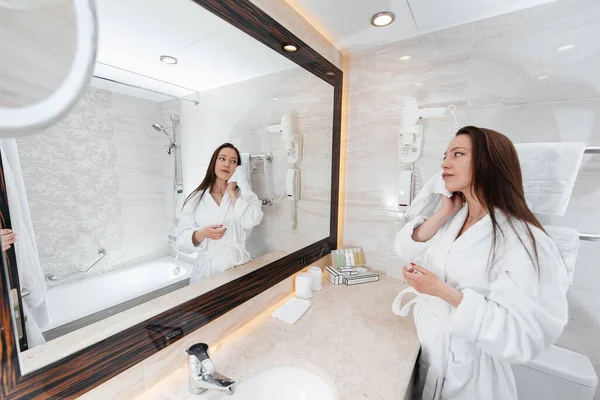 Genç ve güzel bir kız güzel beyaz bir banyoda yıkanır. Otelde taze bir günaydın. Dinlen ve seyahat et. Otel eğlencesi ve turizm..