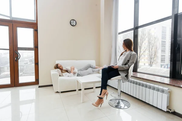 Genç bir kadın bir psikoterapistle görüşmeye geldi. Depresyon sırasında danışmanlık ve yardım. Ofiste bir psikolog ve psikoterapist ile iletişim. Psikolojik yardım.