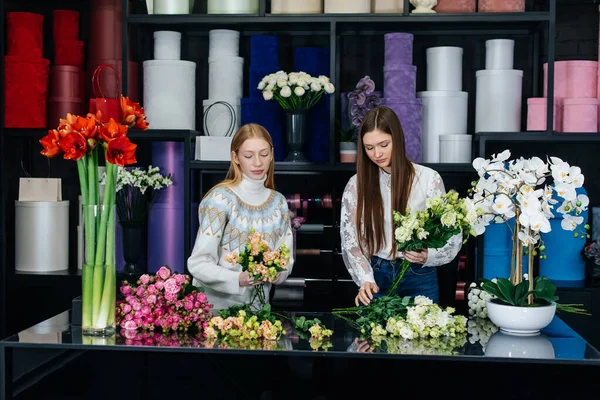 İki genç kadın telefonla sipariş alır ve rahat bir çiçekçide güzel şenlik buketleri yaparlar. Çiçekçi dükkanında çiçek buketi yapıyorlar. Küçük işletme.