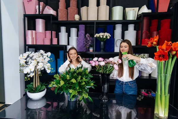 İki genç kadın telefonla sipariş alır ve rahat bir çiçekçide güzel şenlik buketleri yaparlar. Çiçekçi dükkanında çiçek buketi yapıyorlar. Küçük işletme.