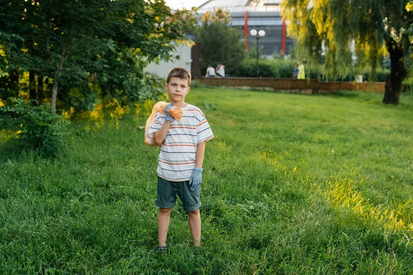 Gün Batımında Yedi Yaşında Bir Çocuk Parkta Çöp Toplamakla Meşgul Stok Fotoğraf