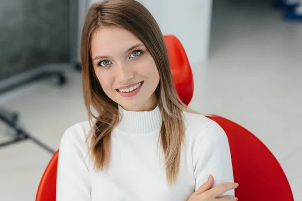 Una Hermosa Mujer Joven Está Sentada Una Silla Dental Roja — Foto de Stock