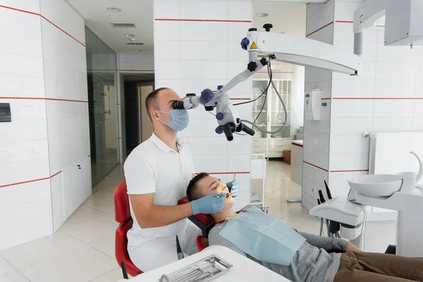 Young Dentist Examines Treats Teeth Young Guy Modern White Dentistry — Stock Photo, Image