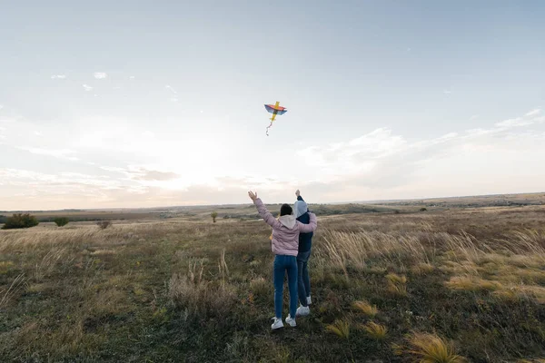 幸せなカップルは凧を飛ばして 自然保護区で屋外で一緒に時間を過ごします 幸せな関係と家族の休暇 自由と空間 — ストック写真
