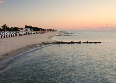 Groemitz Almanya plajında gün batımı güneşli güzel bir yaz gününde açık mavi bir gökyüzü ve birkaç bulutla