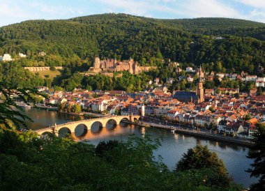 Neckar Nehri üzerinden tarihi şehre ve Heidelberg Almanya 'nın ünlü şatosuna güzel, güneşli bir yaz günü açık mavi bir gökyüzü ve birkaç bulutla bakın.
