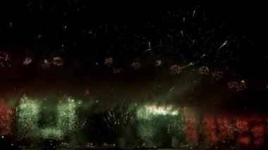 Gerçek havai fişek arka planının kusursuz döngüsü. Gece gökyüzünde bokeh ışıkları olan gerçek altın sarısı havai fişeklerin soyut bulanıklığı. Parlak havai fişek gösterisi. Yeni yıl arifesi havai fişek kutlaması