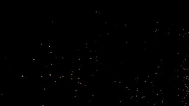 Gece gökyüzündeki büyük ateşten yanan kırmızı kıvılcımlar yükseliyor. Ateş, ışık ve yaşam temasının güzel soyut arkaplanı.