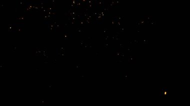 Gece gökyüzündeki büyük ateşten yanan kırmızı kıvılcımlar yükseliyor. Ateş, ışık ve yaşam temasının güzel soyut arkaplanı.