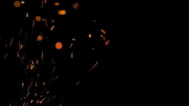 Gece gökyüzündeki büyük ateşten yanan kırmızı kıvılcımlar yükseliyor. Ateş, ışık ve yaşam temasının güzel soyut arkaplanı.