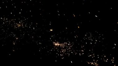 Gece gökyüzündeki büyük ateşten yanan kırmızı kıvılcımlar yükseliyor. Ateş, ışık ve yaşam temasının güzel soyut arkaplanı.