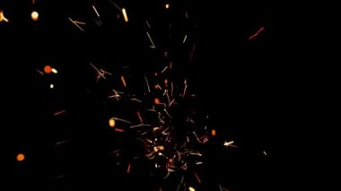 Gece gökyüzündeki büyük ateşten yanan kırmızı kıvılcımlar yükseliyor. Ateş, ışık ve yaşam temasının güzel soyut arkaplanı.