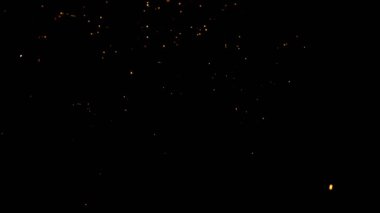 Gece gökyüzündeki büyük ateşten yanan kırmızı kıvılcımlar yükseliyor. Ateş, ışık ve yaşam temasının güzel soyut arkaplanı.