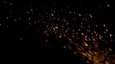 Gece gökyüzündeki büyük ateşten yanan kırmızı kıvılcımlar yükseliyor. Ateş, ışık ve yaşam temasının güzel soyut arkaplanı.