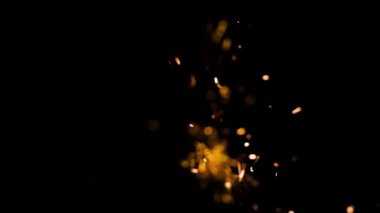 Gece gökyüzündeki büyük ateşten yanan kırmızı kıvılcımlar yükseliyor. Ateş, ışık ve yaşam temasının güzel soyut arkaplanı.