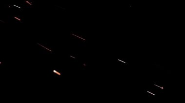 Gece gökyüzündeki büyük ateşten yanan kırmızı kıvılcımlar yükseliyor. Ateş, ışık ve yaşam temasının güzel soyut arkaplanı.