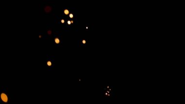 Gece gökyüzündeki büyük ateşten yanan kırmızı kıvılcımlar yükseliyor. Ateş, ışık ve yaşam temasının güzel soyut arkaplanı.