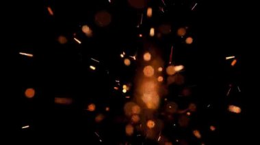 Gece gökyüzündeki büyük ateşten yanan kırmızı kıvılcımlar yükseliyor. Ateş, ışık ve yaşam temasının güzel soyut arkaplanı.