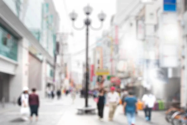 Blurred image of tourist crowd walking on shopping street in asia city during the day.
