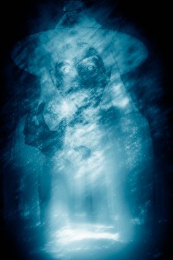 Horror on Halloween night appears shadow of witch in dark forest.