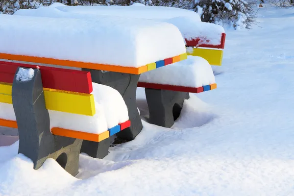 Bunte Bänke im Winter mit viel Schnee — Stockfoto