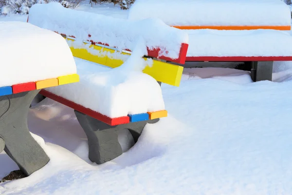 Bunte Bänke im Winter mit viel Schnee — Stockfoto