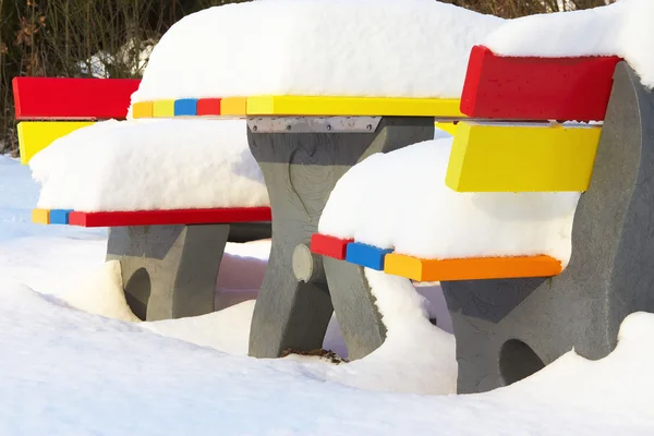 Bancs extérieurs colorés en hiver avec beaucoup de neige — Photo