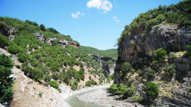 Arnavutluk 'un Permet bölgesindeki bir kanyonda yer alan bir termal kaynak görüntüsü.                      