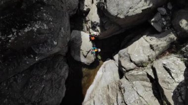 Tanımlanamayan iki insan öpüşebilir. Üç Kanadalı bir şelalenin yanındaki nehir kanyonuna doğru ilerliyorlar. Ardeche boğazı, Güney Fransa
