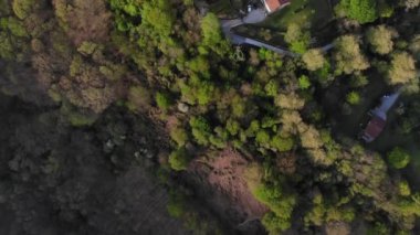 Drone flying over several isolated rural houses at the base of a green valley. Rural tourism concept