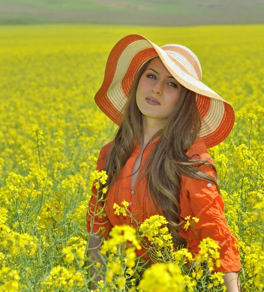 Beautiful woman on blooming rapeseed field — Stock Photo, Image