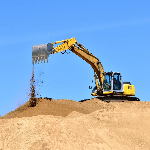 Nový žlutý bagr pracuje na písečných dunách — Stock fotografie