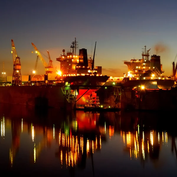 Ship are being fixed and painted at the shipyard docks by night — Stock Photo, Image