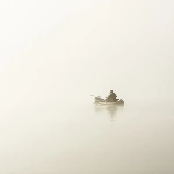 Fisherman in boat in fog — Stock Photo, Image