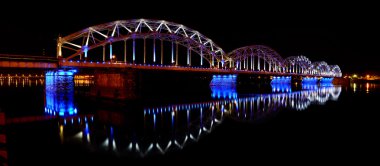 Riga, Letonya demiryolu Köprüsü ile gece panoramik sahne