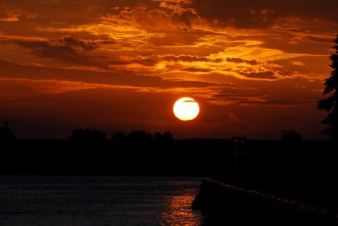 güneş doğarken nehir kıyısında. Ventspils, Letonya