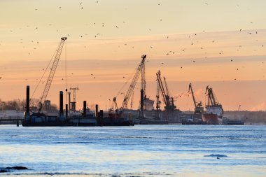 Gün doğumunda Riga limanında kargo terminali