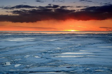 karlı Baltık Denizi sahilinde renkli günbatımı