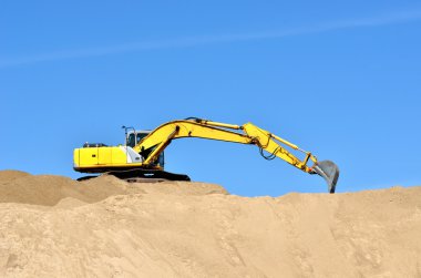 Yeni sarı ekskavatör kum tepeleri üzerinde çalışma