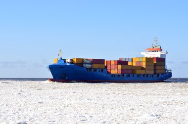 kargo gemisi durgun suda hareket ediyor.
