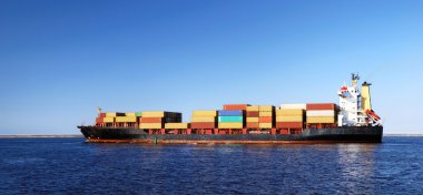 kargo gemisi durgun suda hareket ediyor.