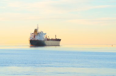 Kargo gemisi renkli günbatımında yelken açıyor.