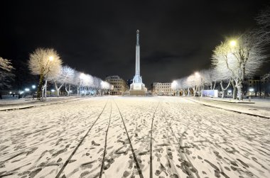 Riga Park 'ta karlı bir kış gecesi ve Milda - Özgürlük anıtı