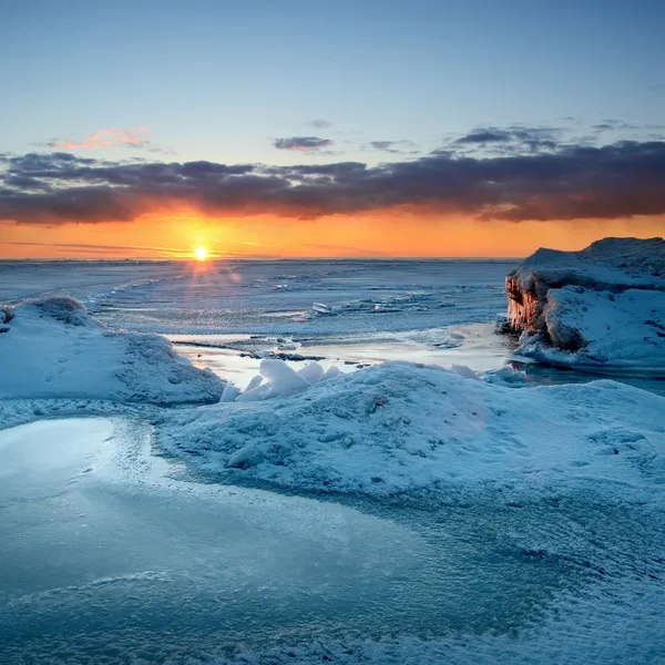 Pôr-do-sol colorido na costa nevada do mar Báltico — Fotografia de Stock