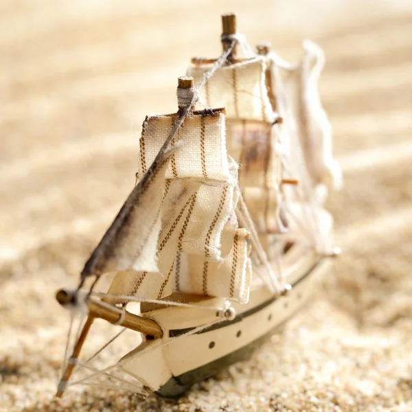 Modelo de brinquedo de navio de vela de madeira na areia do mar close-up — Fotografia de Stock