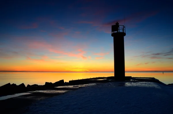 Phare dans la mer au coucher du soleil coloré — Photo