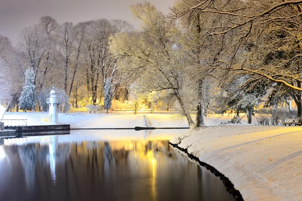 Neve em árvores no parque e farol de Riga — Fotografia de Stock