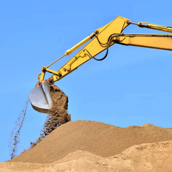 Nieuwe gele graafmachine bezig met zandduinen. Scoop close-up — Stockfoto