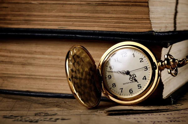 Vintage pocket clock and old books — Stock Photo, Image